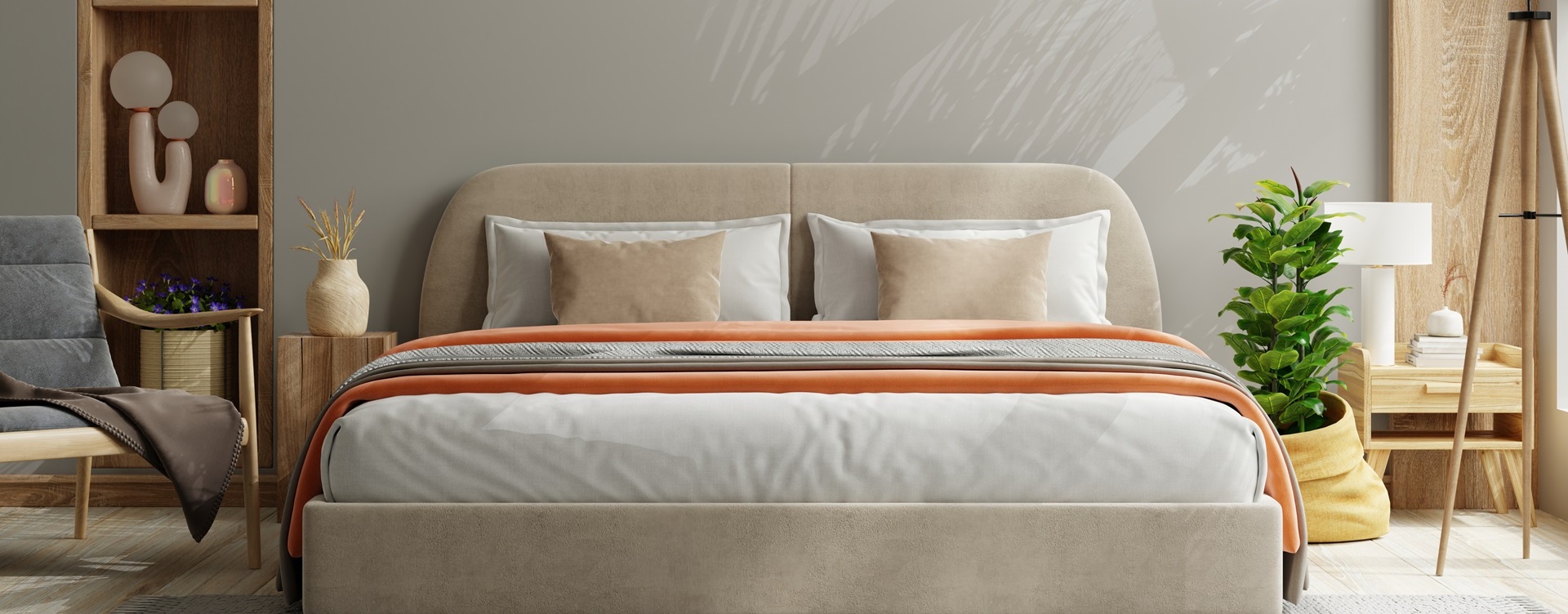 A modern bedroom in Rancho Santa Margarita showcases a beige bed with orange and white bedding. A plant to the right, a chair to the left, and wooden shelves displaying decor complete the scene—all easily maintained by a local household items cleaning service.